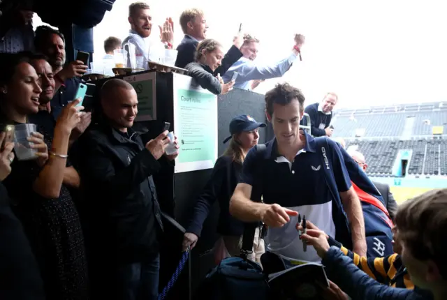 Andy Murray walks through the crowd, who are taking pictures of him