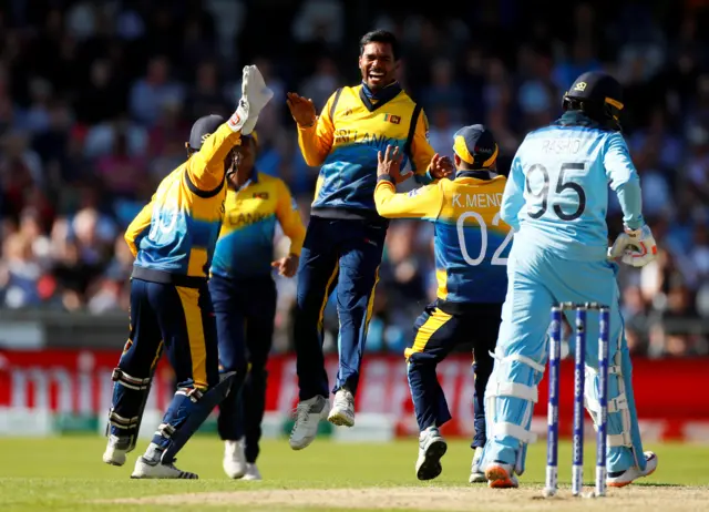 Dhananjaya de Silva celebrates taking the wicket of England"s Adil Rashid caught by Kusal Perera