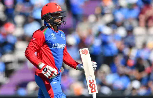 Gulbadin Naib walks back to the pavilion after his dismissal