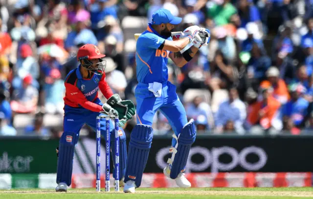 Virat Kohli (R) plays a shot as Afghanistan"s Ikram Ali Khil looks on