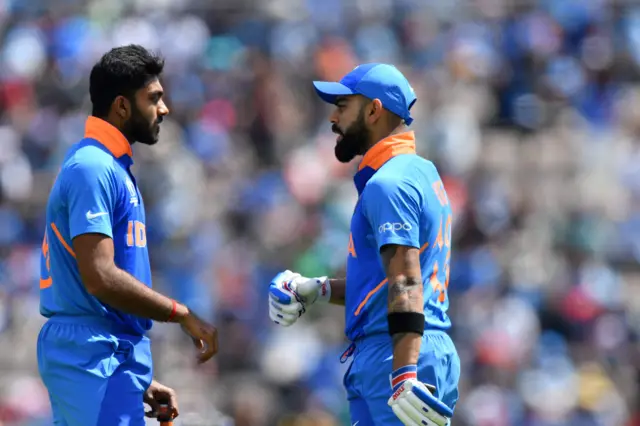 Virat Kohli (R) speaks with India"s Vijay Shankar at a drinks break