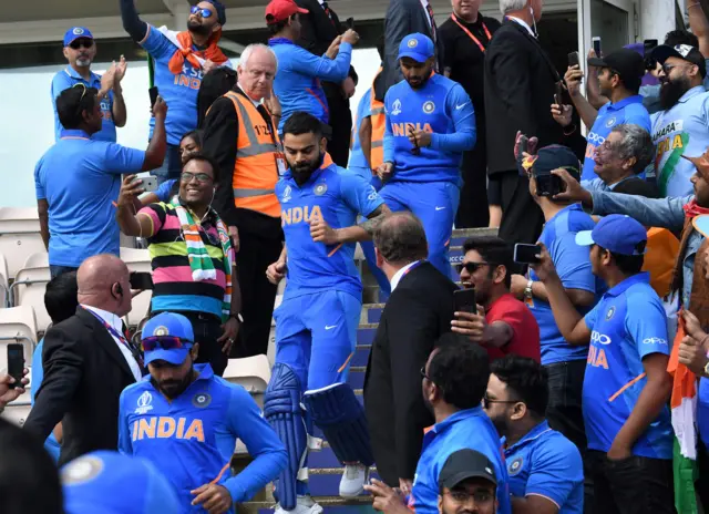 Captain Virat Kohli (C) walks out onto the field ahead of the 2019 Cricket World Cup group stage match between India and Afghanistan