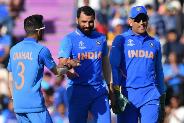 Mohammed Shami (C) celebrates with Mahendra Singh Dhoni (R) and Yuzvendra Chahal (L) after the dismissal of Afghanistan"s Mohammad Nabi