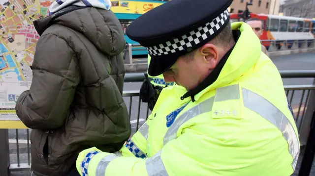 Generic of man being searched by a police officer