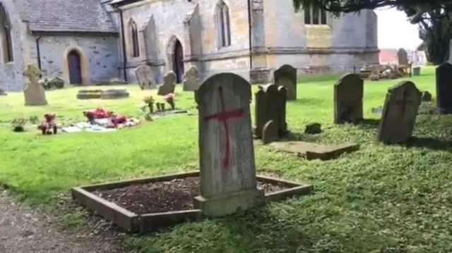 Crosses sprayed onto gravestones