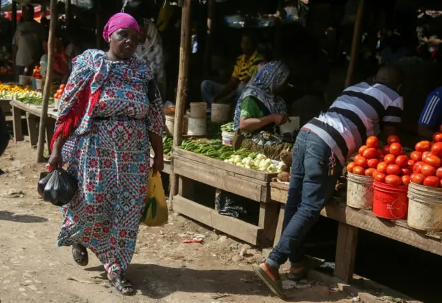 Woman walking past a market stall