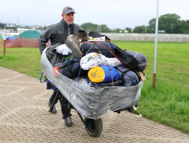 Camping kit being pushed in a wheelbarrow