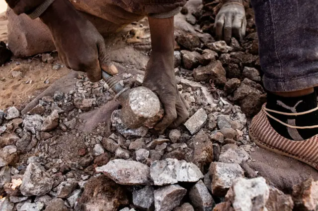 A miner breaks up small chunks of cobalt