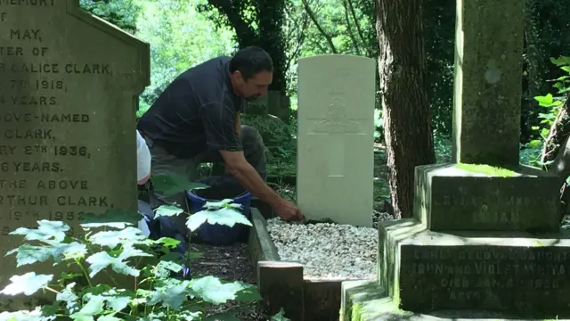 A man tending to the headstones