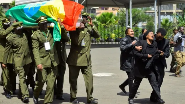 Soldiers carry a coffin while a woman cries alongside in Addis Ababa, Ethiopia