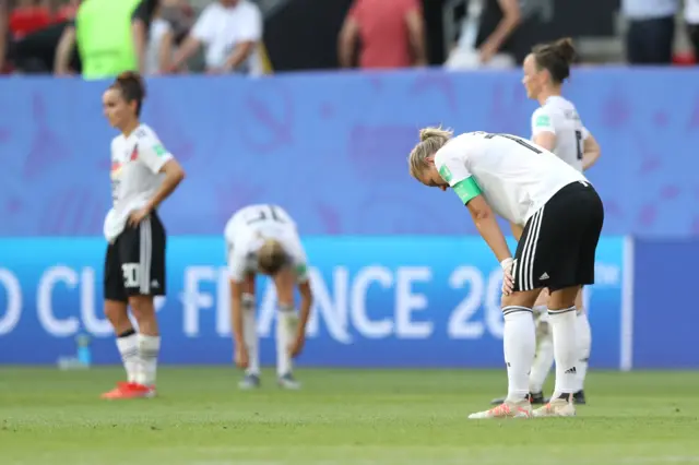 Alexandra Popp and her Germany team-mates with heads bowed at full time