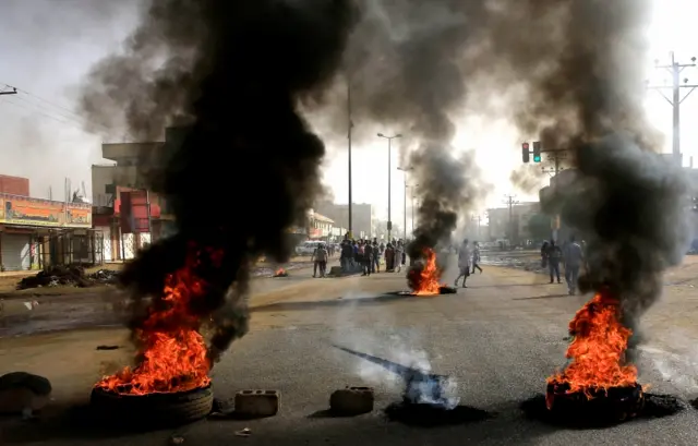 Sudanese protesters use burning tyres to erect a barricade on a street, demanding that the country"s Transitional Military Council hand over power to civilians