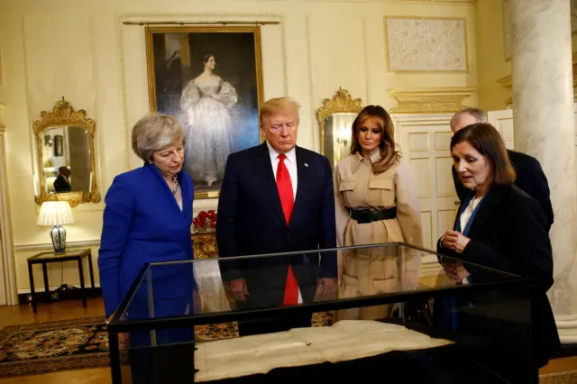 Theresa May, Donald Trump and Melania Trump being shown the Sussex Declaration