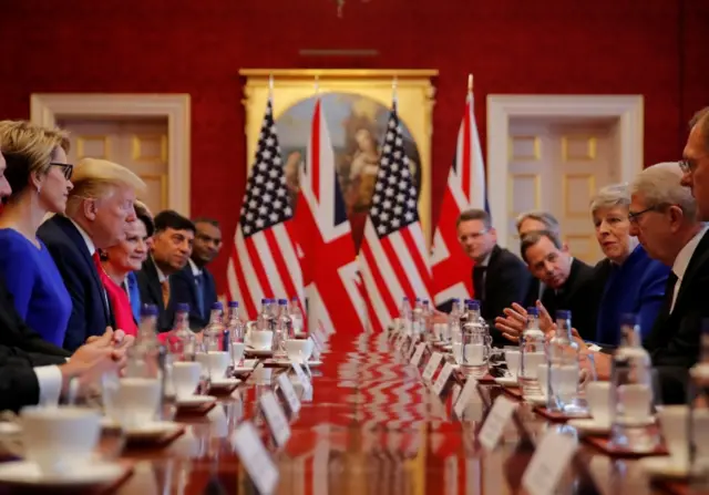 Donald Trump and Theresa May sitting at a business roundtable meeting