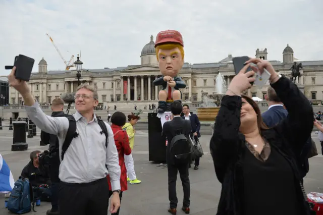 People taking photos with the Donald Trump effigy