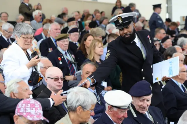 Members of the British Royal Navy helping to hand out programmes