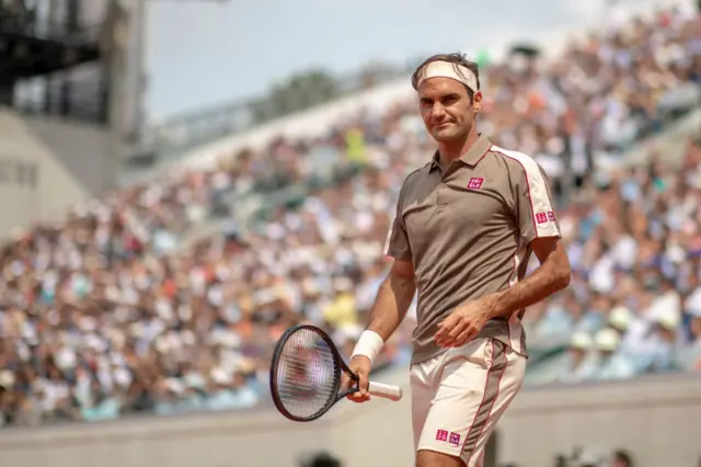 Roger Federer smiles on court