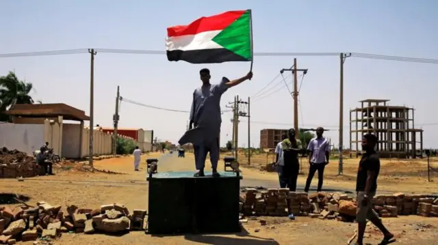 Man holding Sudanese flag