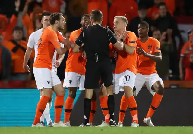 Dutch players surround referee