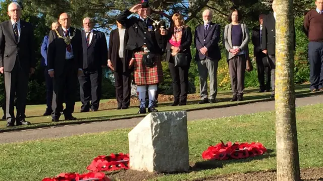 A man laying a wreath