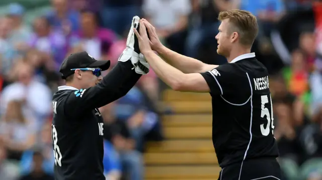 Jimmy Neesham and Tom Latham celebrate taking a wicket