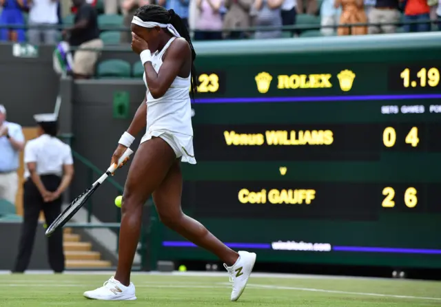 Cori Gauff reacts with the scoreboard in the background showing the stats of her two-set victory over Venus Williams