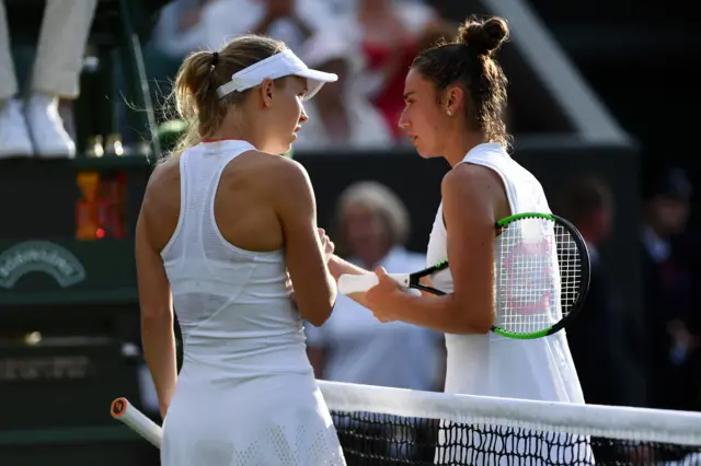 Caroline Wozniacki of Denmark speaks with Sara Sorribes Tormo at the net after she was forced to pull out through injury