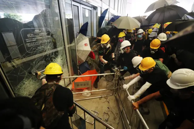 Protesters attempt to break the glass at the Legislative Council