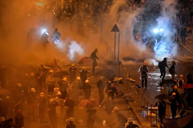 Police fire tear gas at protesters near the government headquarters in Hong Kong