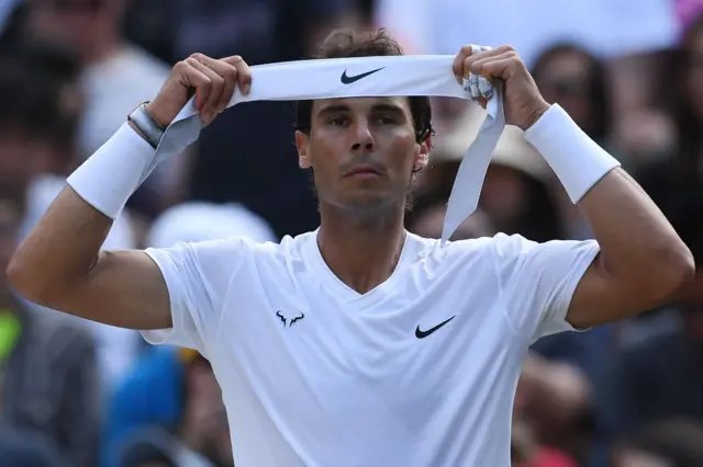 Rafael Nadal puts on a headband