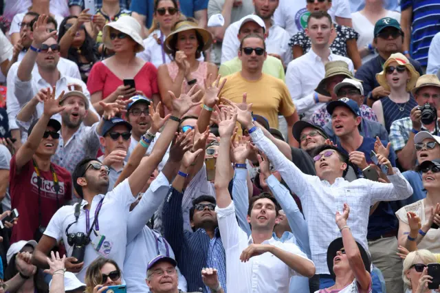 Spectators try to catch a wristband