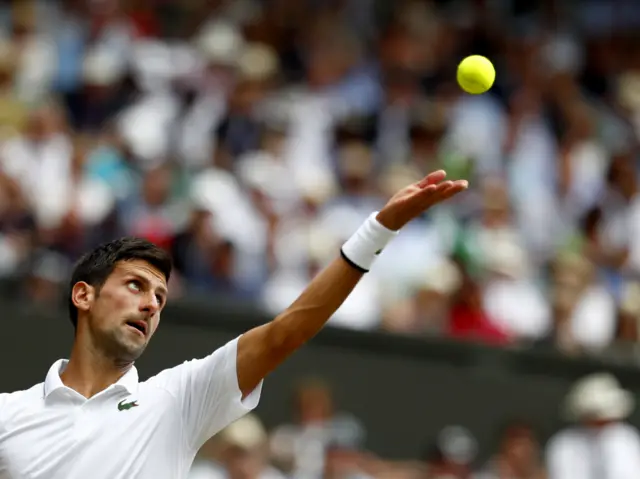 Novak Djokovic tosses the ball to serve