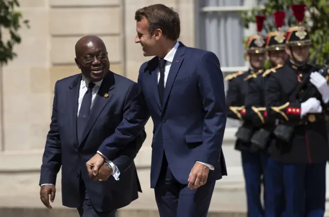 French President Emmanuel Macron (R) greets Ghana's President Nana Addo Dankwa Akufo-Addo as he arrives at the Elysee Palace in Paris on 11 July 2019.