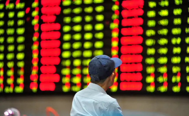 An investor watches an electronic ticker board displaying stock figures at a stock exchange hall on July 8, 2019 in Nanjing, Jiangsu Province of China.