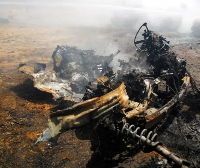 The wreckage of a car is seen at the site where a car bomb hit a funeral of a former senior military commander at Huwari cemetery in Benghazi, Libya.