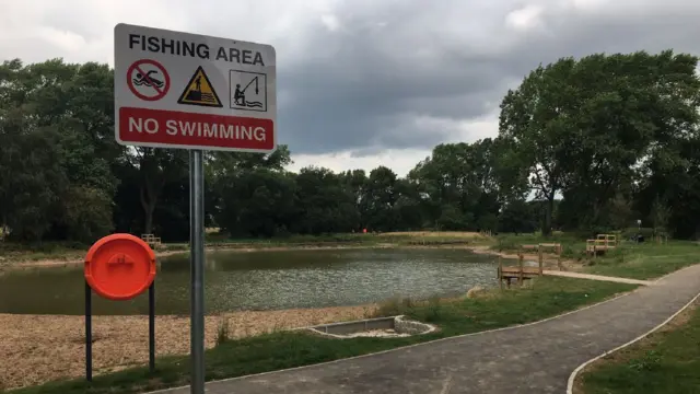 A sign warning against swimming in the pond