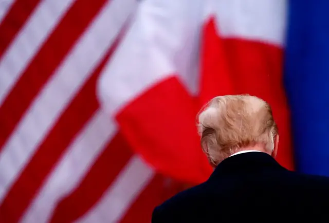 Donald Trump in front of US and French flags