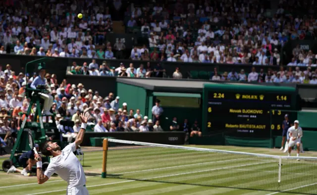 The crowd are still as Novak Djokovic serves, leading by one set to love but trailing 5-3 in the second set