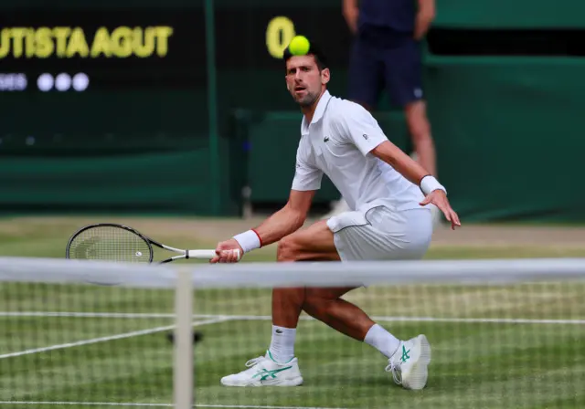 Novak Djokovic cushions a volley at the net