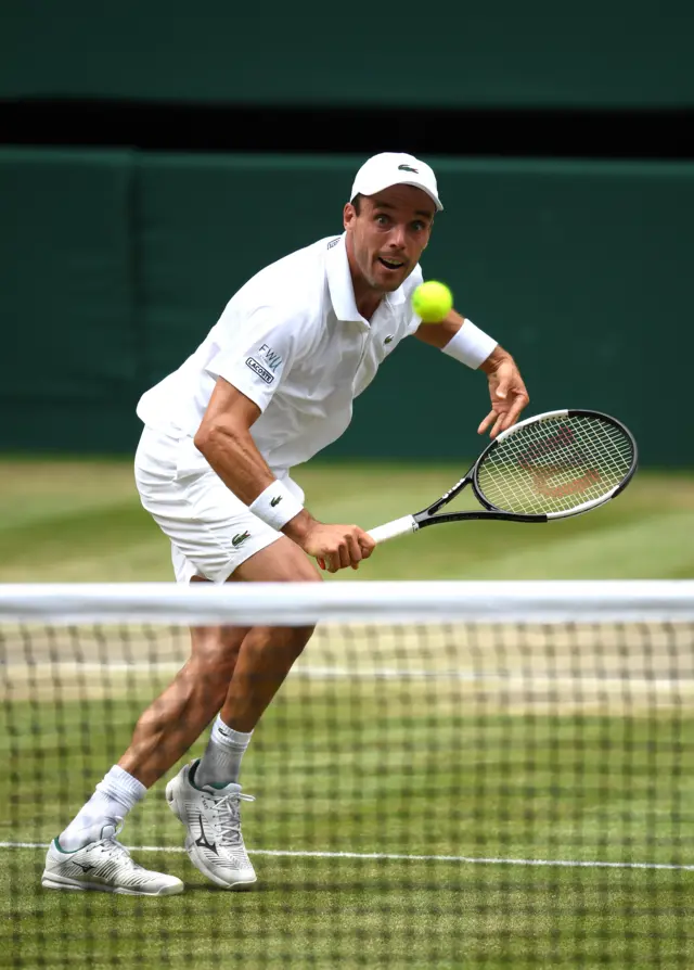 Roberto Bautista Agut volleys at the net