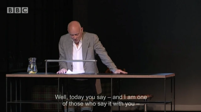An actor reads at a table