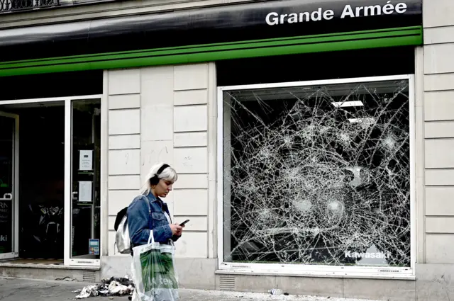 Woman walking beside cracked glass