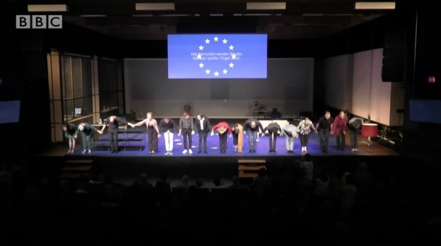 The cast on stage, taking a bow