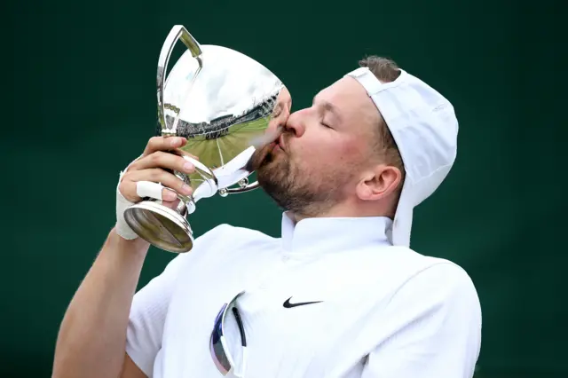 Dylan Alcott, of Australia, kisses the trophy after winning the men's quad singles title