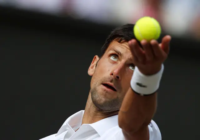 Novak Djokovic throws up the ball to serve