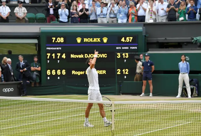 Novak Djokovic looks to the sky with the scoreboard in the background