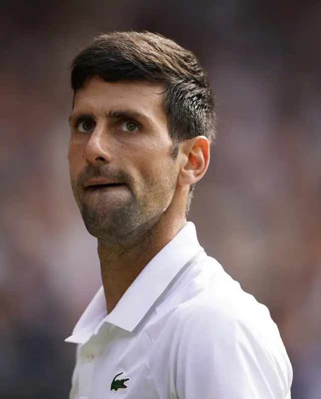 Novak Djokovic looks to his box