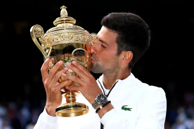 Novak Djokovic kisses the Wimbledon trophy