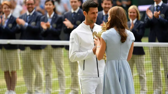 Novak Djokovic accepts the trophy from the Duchess of Cambridge