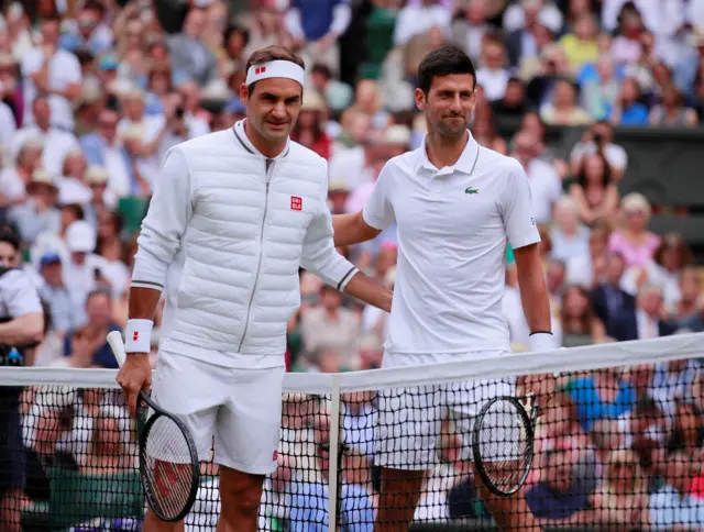 Roger Federer and Novak Djokovic embrace at the net